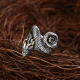 Bague serpent en cuivre avec un serpent très réaliste posée sur un contenant en paille.