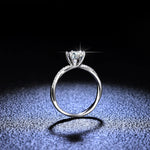 Bague solitaire diamant en argent 925 vue de profil posée sur un fond sombre.