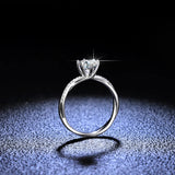 Bague solitaire diamant en argent 925 vue de profil posée sur un fond sombre.