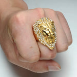 Main d'homme portant une bague tête de lion dorée faite en acier.
