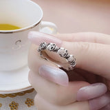 Bague tête de mort femme avec un anneau en crâne, tenue entre les mains d'une dame.