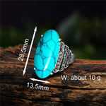 Bague turquoise avec un anneau en alliage de zinc couleur argent et une turquoise synthétique ovale.
