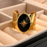 Bague bohème à taille ajustable en acier doré avec une pierre ovale noire.