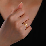 Bagues dents en acier doré portée sur l'annulaire d'une femme.