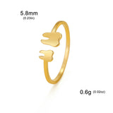 Bague dents en acier inoxydable doré avec deux pendentifs en forme de dents.