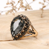 Bagues ethniques dorée pour femme avec des cristaux noirs et une pierre ovale noire.