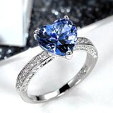 Bagues solitaires à anneau serti de zircones et pierre centrale bleue en forme de coeur.