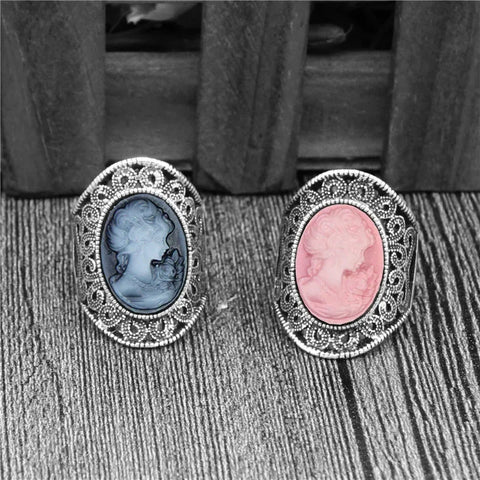 Deux camées bagues porsées sur une table, une avec une pierre bleue et une avec une pierre rose.