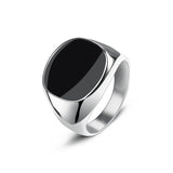 Chevalière homme en acier inoxydable argenté avec une pierre ovale noire brillante.