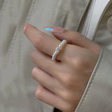 Elastique bague en perles portée sur l'index d'une femme.