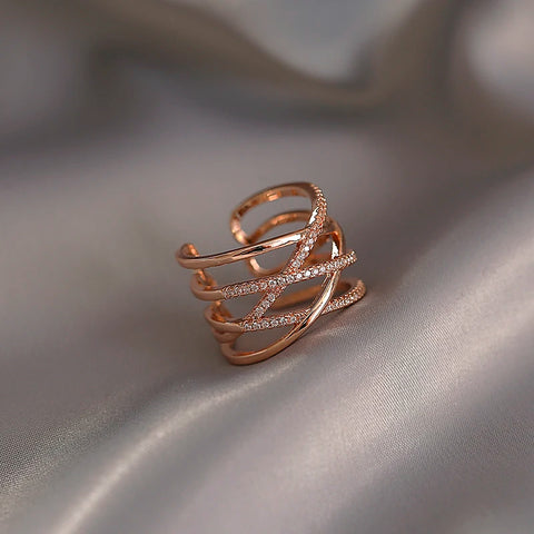 Grosse bague en laiton couleur rose gold avec plusieurs anneaux sertis de pierres.