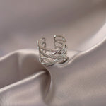 Grosse bague en laiton couleur argent avec de multiples anneaux, certains lisses et certains pavés de pierres.