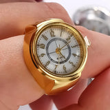 Montre bague doré portée sur l'index d'une femme.