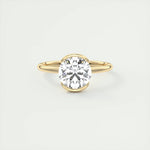 Bague solitaire dorée en argent 925 avec pierre centrale brillante posée sur la table.