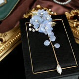 Petite broche fleur mariage avec au bout de son pendentif une perle blanche